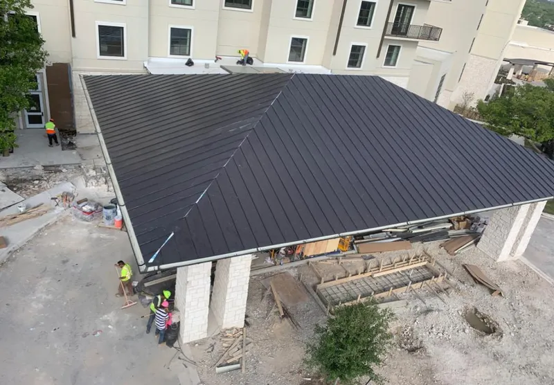 Metal roofing installation team working on a commercial building in Center